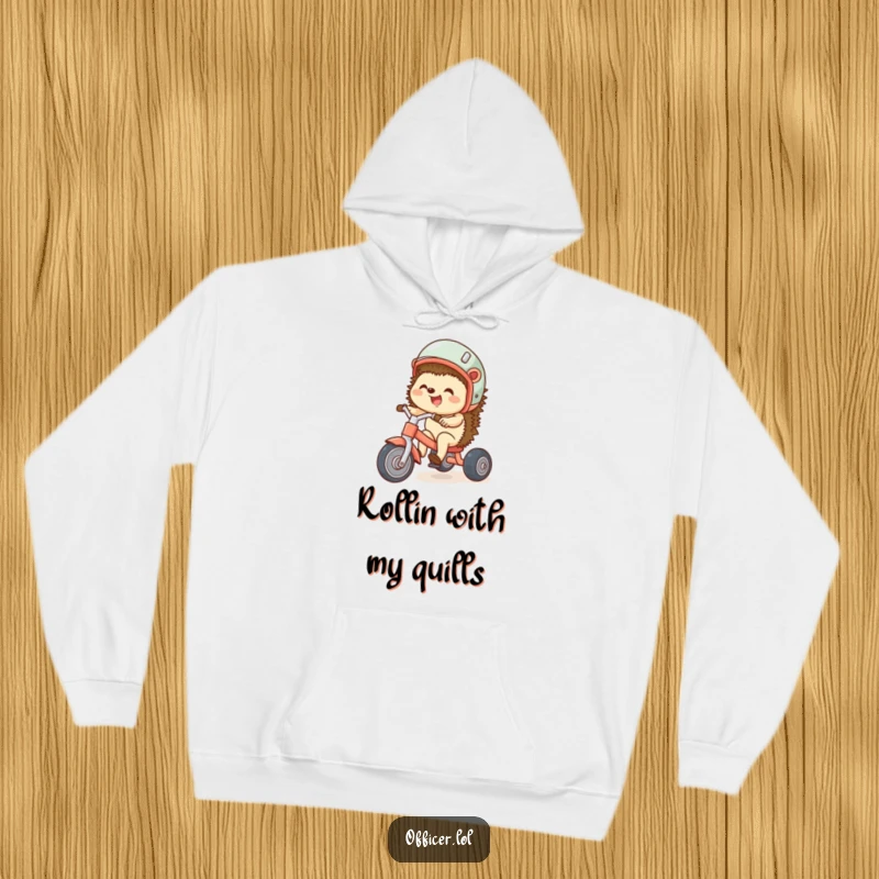 Funny hoodie featuring a giggling hedgehog sporting a helmet while riding a tiny tricycle, exuding happiness and playful energy.